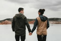Couple se tenant la main face à un lac — quand consulter un thérapeute de couple à Lausanne