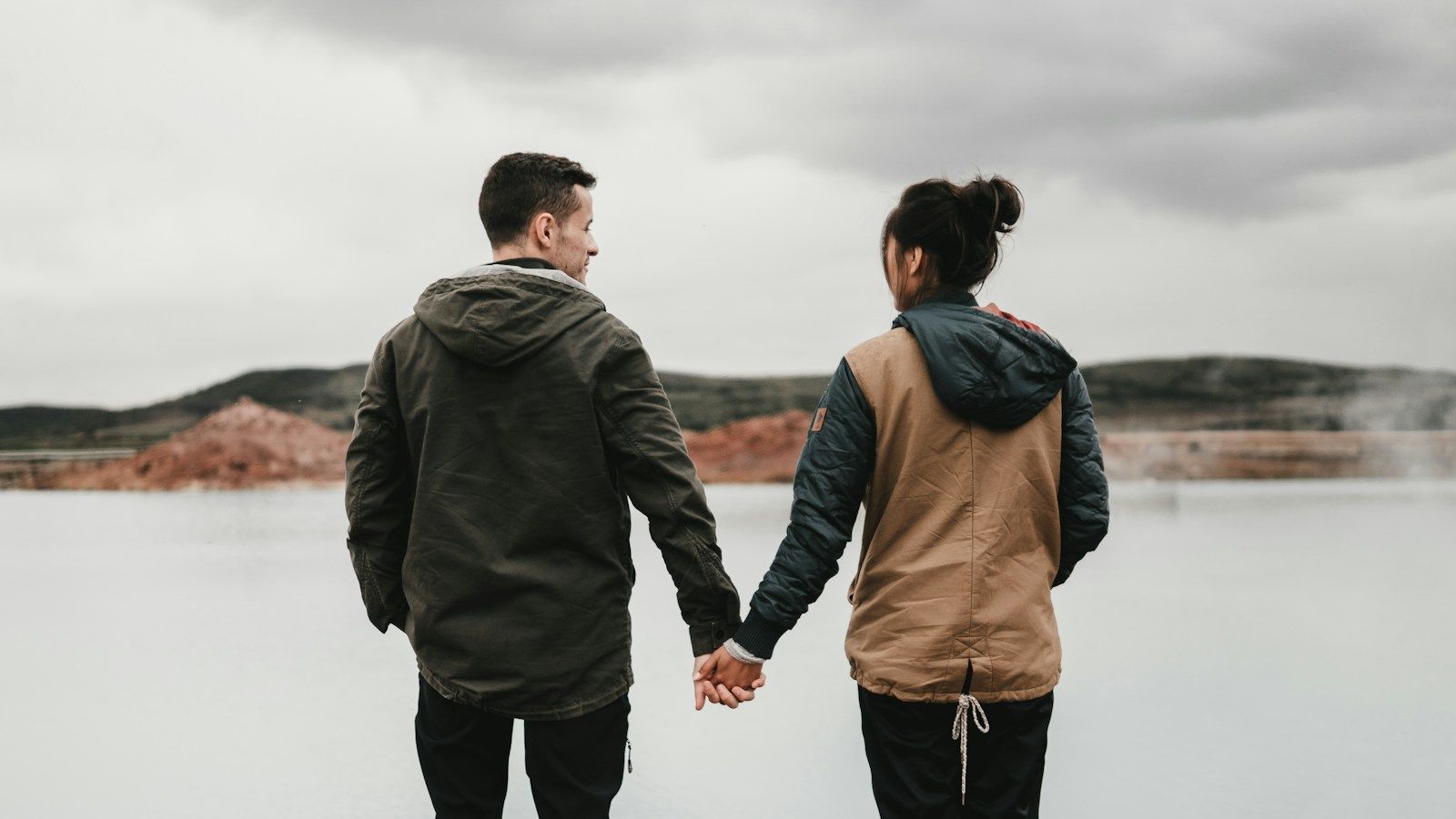 Couple se tenant la main face à un lac — quand consulter un thérapeute de couple à Lausanne